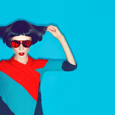 moda saç kesimi ve mavi bir bac üzerinde güneş gözlüğü ile esmer modeli