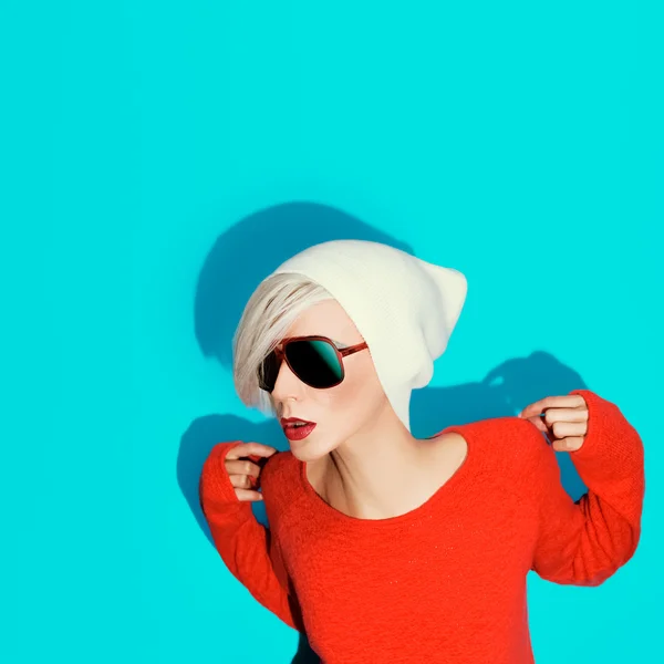 Chica rubia de moda con sombrero de moda y gafas de sol en una espalda azul — Foto de Stock