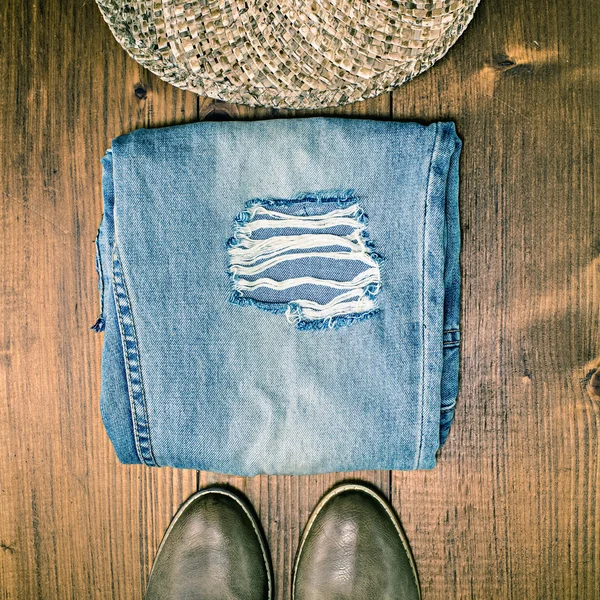 Calça jeans e chapéu no chão de madeira — Fotografia de Stock