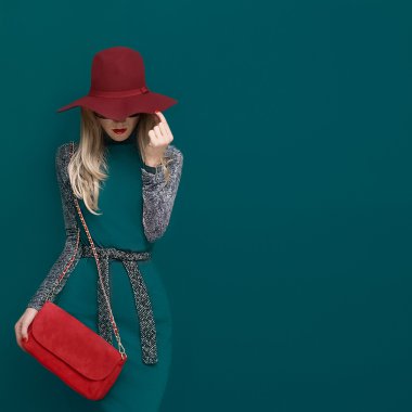 Lovely blond model in fashionable red hat and a red clutch on gr clipart