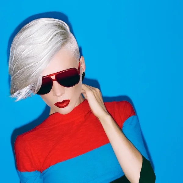 Fashion blond lady with trendy hairstyle and sunglasses on a blu — Stock Photo, Image