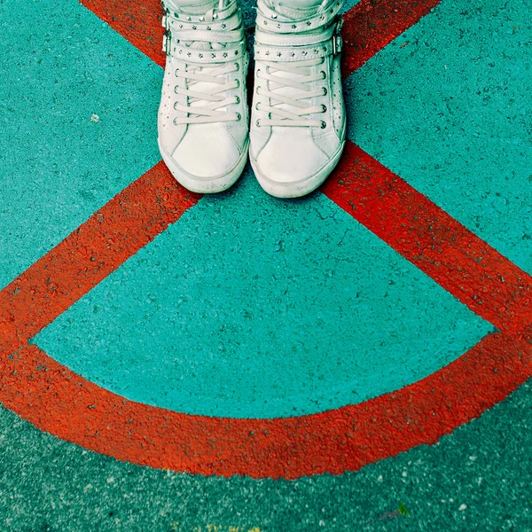 Женские кроссовки на фоне города. Стильная модная обувь — стоковое фото
