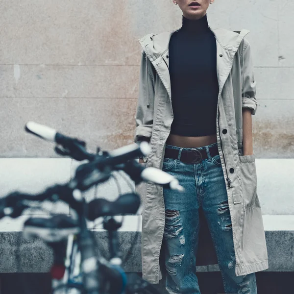 Rapariga na rua. estilo urbano. Manto e jeans rasgados . — Fotografia de Stock