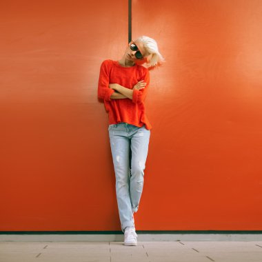 Şık sarışın kırmızı şehir sokak duvara yakın dur. Kentsel Casual 