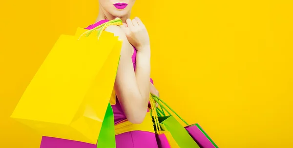 Senhora glamourosa com compras em fundo amarelo brilhante — Fotografia de Stock