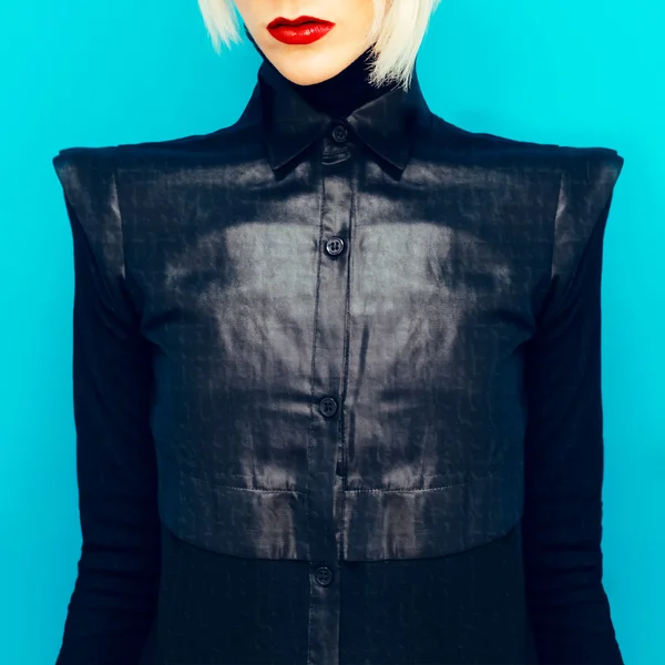 Blond tjej i fashionabla svart tröja på blå bakgrund — Stockfoto