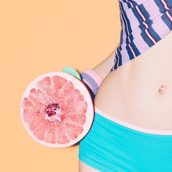 Summer girl with grapefruit. Tropical style, fashionable clothes — Stock Photo, Image