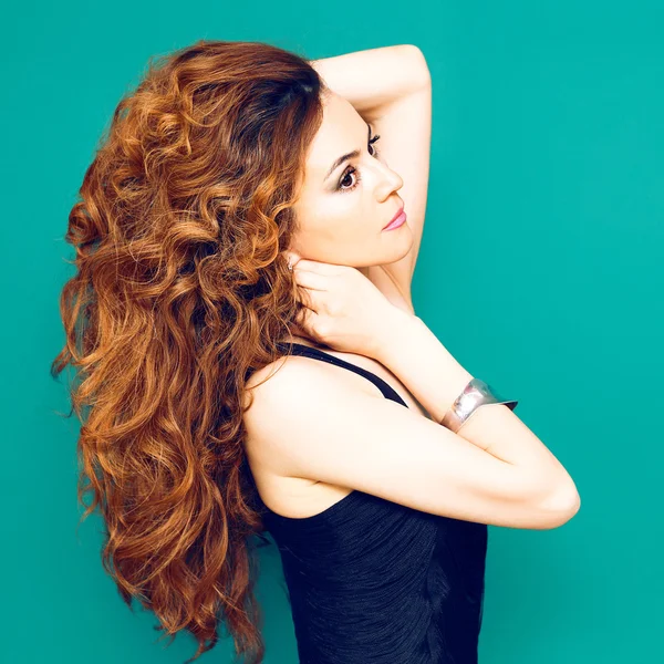 Señora de la moda con el pelo rizado rojo largo sobre fondo azul — Foto de Stock