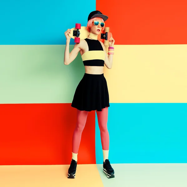 Glamour model holding skateboard on bright exclusive batskground — Stock Photo, Image