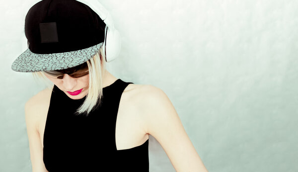 DJ girl in cap and stylish headphones