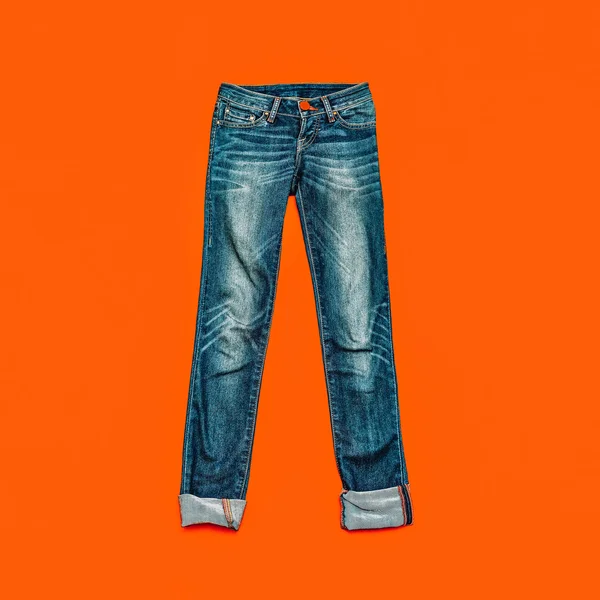 Calça jeans azul sobre fundo laranja brilhante — Fotografia de Stock