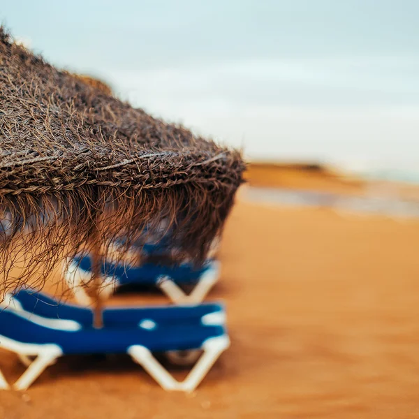 Paraguas de paja en la playa. primer plano — Foto de Stock