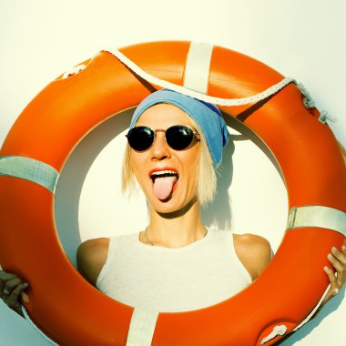 Blonde model plays the fool on the background wall with orange l