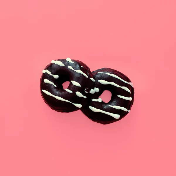 巧克力甜甜圈上粉红色香草背景 — 图库照片