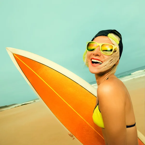Счастливая девушка-серфер со стильной доской для серфинга на пляже. Серфинг — стоковое фото