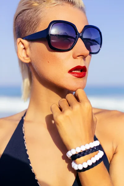 Elegante dama de vacaciones en gafas de sol de moda en la playa —  Fotos de Stock