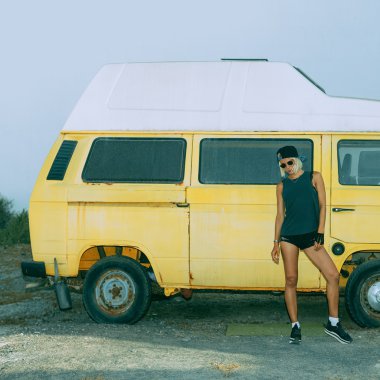 Şık kız vintage minibüs duruyor. Kentsel moda stil