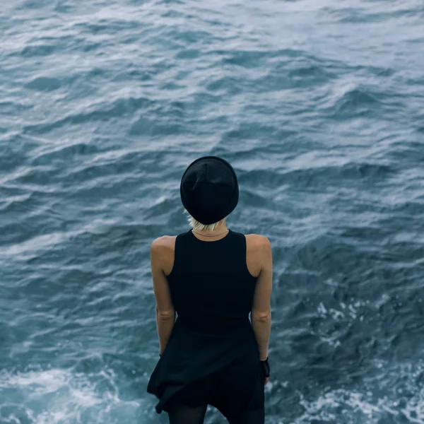 Sensuele meisje staand op het rotsmassief op de Oceaan — Stockfoto