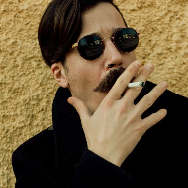 Şık hipster adam sigara içiyor. Son moda sonbahar bak. Kentsel tarzı