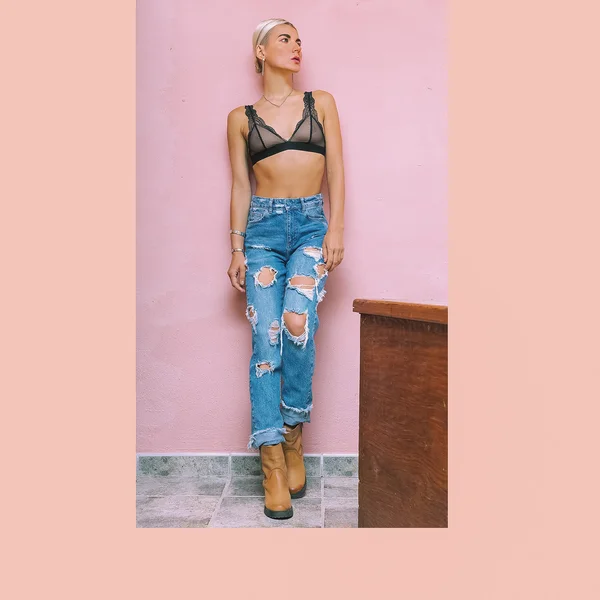Sinnliche Dame in modischen Jeans an der Wand — Stockfoto