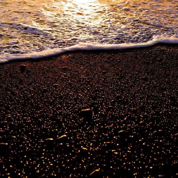 Černý písek. Oceán. západ slunce — Stock fotografie