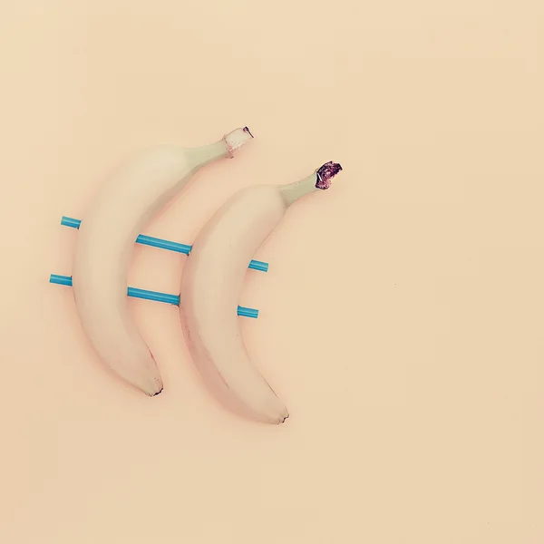 Minimalismus styl. Dvě trubice propíchnuté banány — Stock fotografie