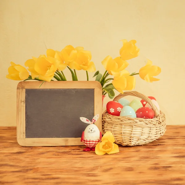 Oeufs de Pâques, fleurs et tableau blanc — Photo