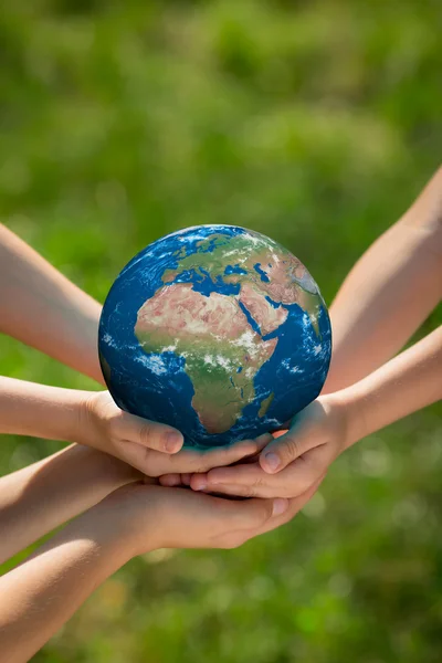 Children holding Earth planet in hands — Stock Photo, Image