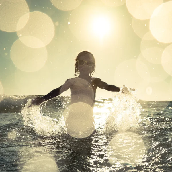 Criança feliz brincando no mar — Fotografia de Stock