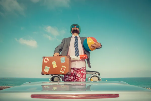 Бизнесмен, стоящий на пляже возле автомобиля — стоковое фото