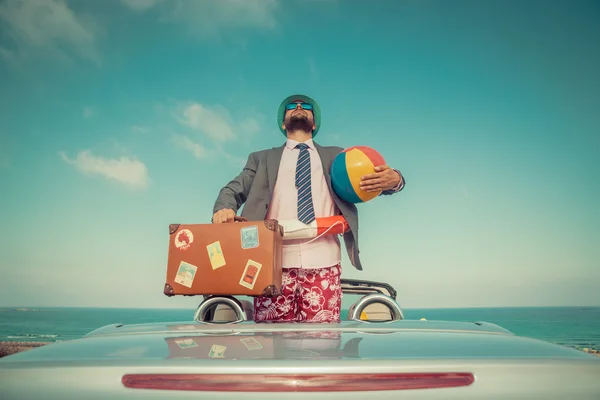 Zakenman permanent op een strand in de buurt van auto — Stockfoto