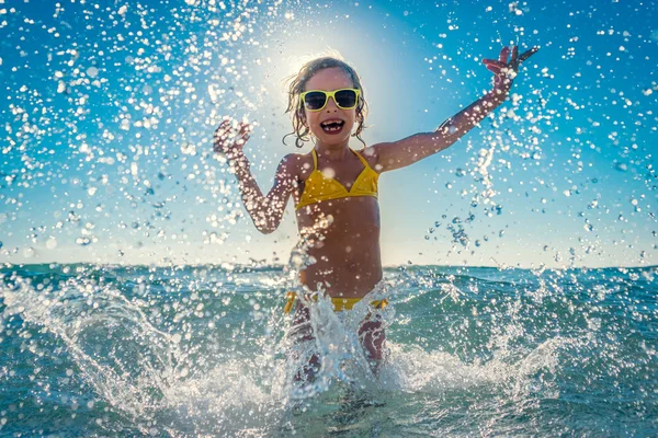 Szczęśliwe dziecko bawiące się w morzu — Zdjęcie stockowe