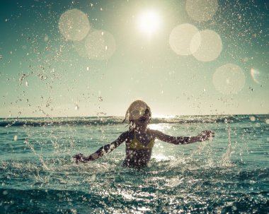 Denizde oynayan mutlu çocuk