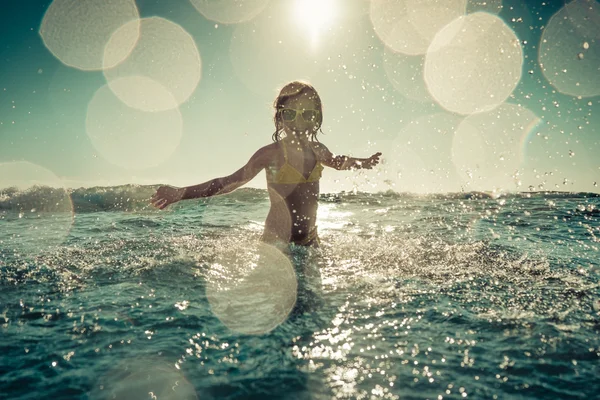 Criança feliz brincando no mar — Fotografia de Stock