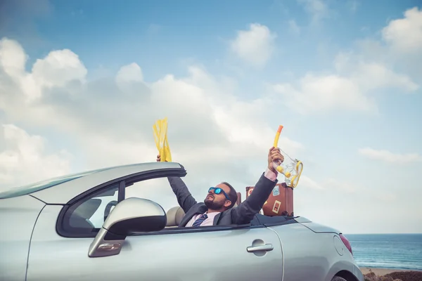 Empresário de pé em uma praia perto de carro — Fotografia de Stock