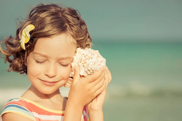 Niño con concha en la playa —  Fotos de Stock