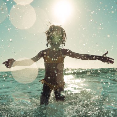 Denizde oynayan mutlu çocuk