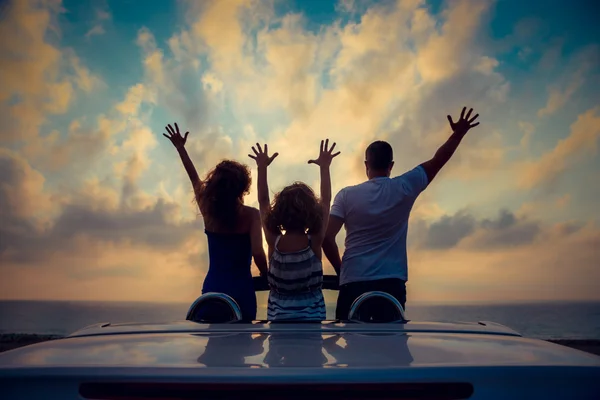 Silhueta de família relaxante na praia — Fotografia de Stock