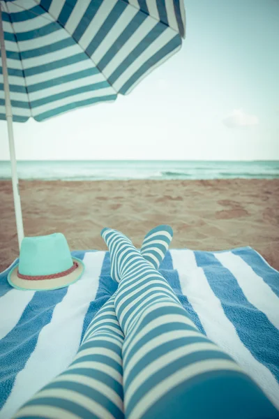 Štíhlá žena nohy na pláži — Stock fotografie