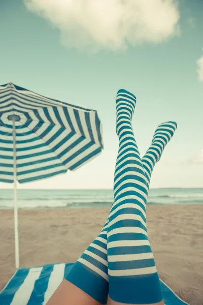 Slim piernas de mujer en una playa — Foto de Stock