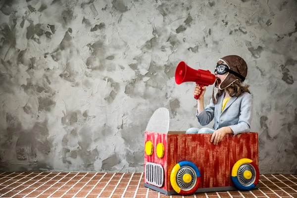 Barnet kör bil tillverkad av kartong — Stockfoto