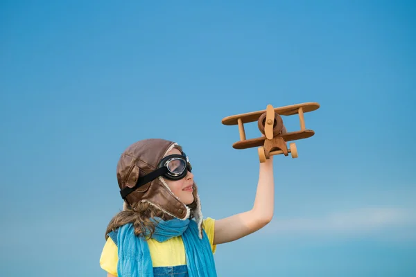 Happy kid playing with airplane outdoors — Stock Photo, Image