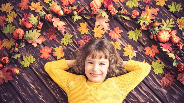 Sonbahar yaprakları üzerinde yatan çocuk — Stok fotoğraf