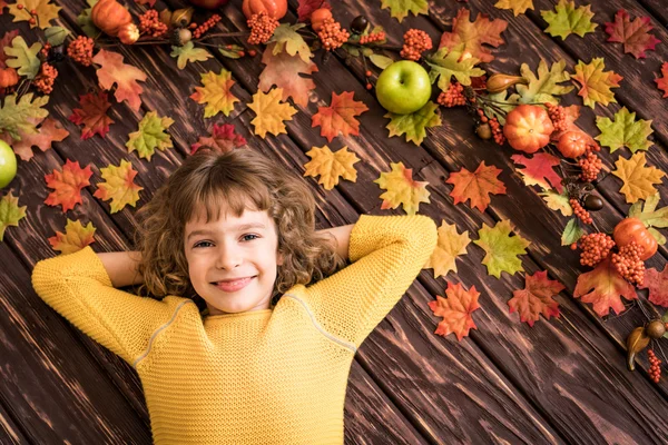 Sonbahar yaprakları üzerinde yatan çocuk. — Stok fotoğraf