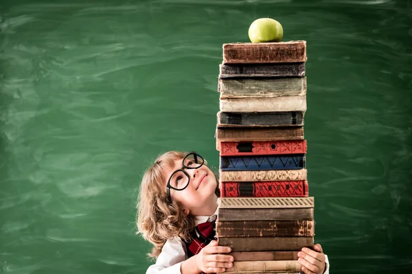 Kind in der Klasse hält Bücher. — Stockfoto