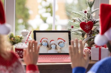 Mutlu aile Noel tatilini karantinada görüntülü sohbet ederek kutluyor. Kilitlenme evde kalma kavramı. Salgın sırasında Xmas partisi Coronavirus COVID 19