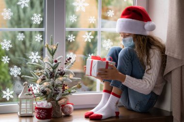 Üzgün çocuk Noel zamanı evde kalır. Salgın Coronavirus COVID 19 konsepti sırasında kış tatili
