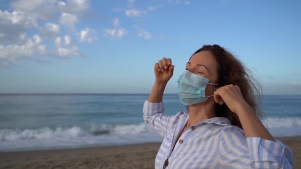 Szczęśliwa Kobieta Nosi Maskę Medyczną Świeżym Powietrzu Przed Błękitnym Tle — Wideo stockowe