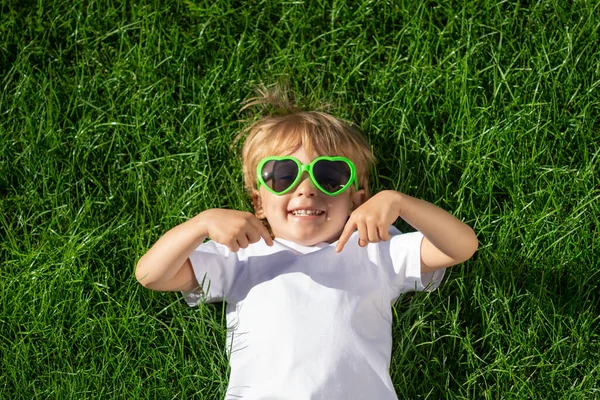 Szczęśliwe Dziecko Wskazuje Palcem Koszulkę Zabawny Dzieciak Wiosennym Zielonym Tle — Zdjęcie stockowe