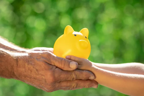 Família Segurando Banco Porquinho Nas Mãos Contra Fundo Primavera Verde — Fotografia de Stock